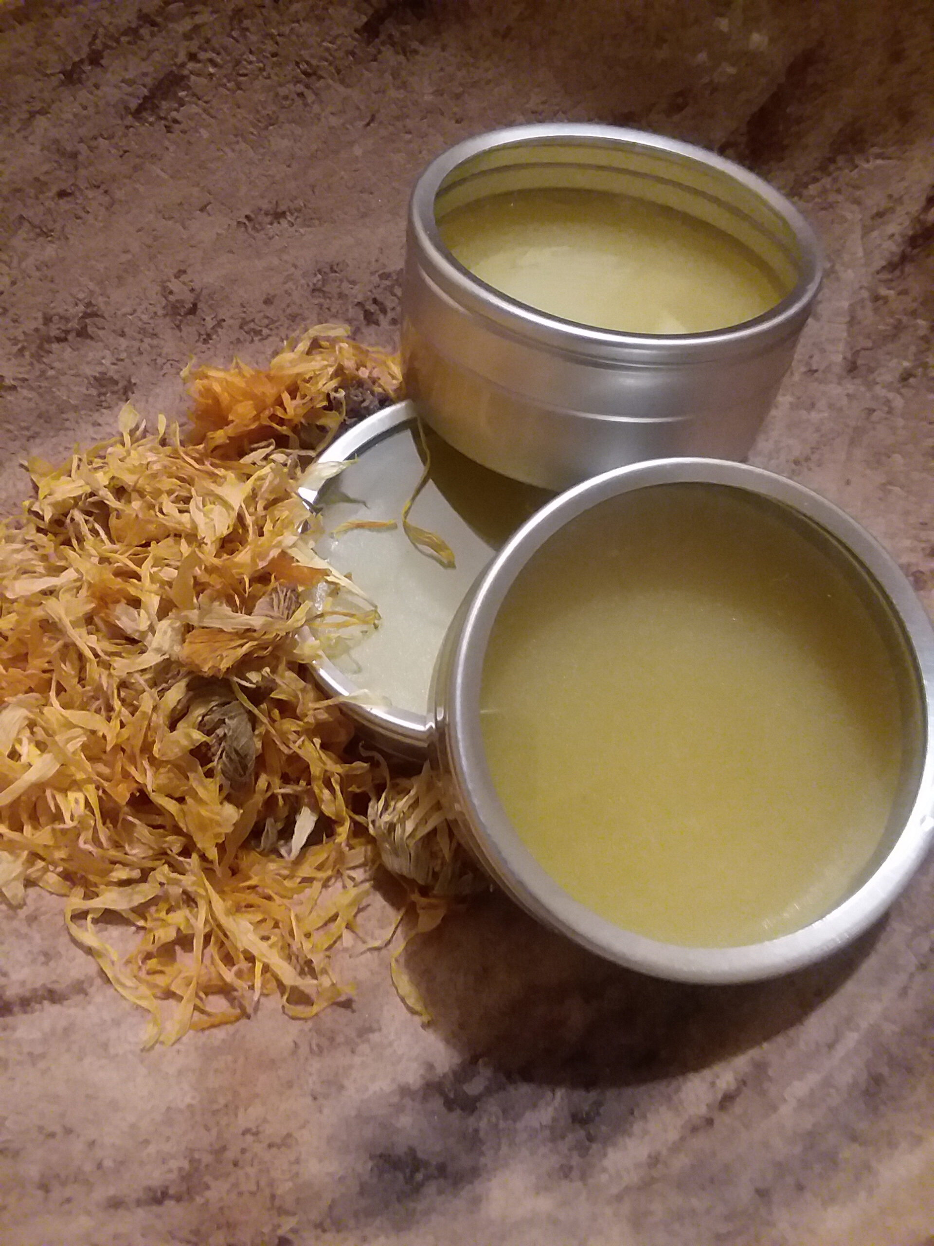 salve in tins with dried calendula on the table