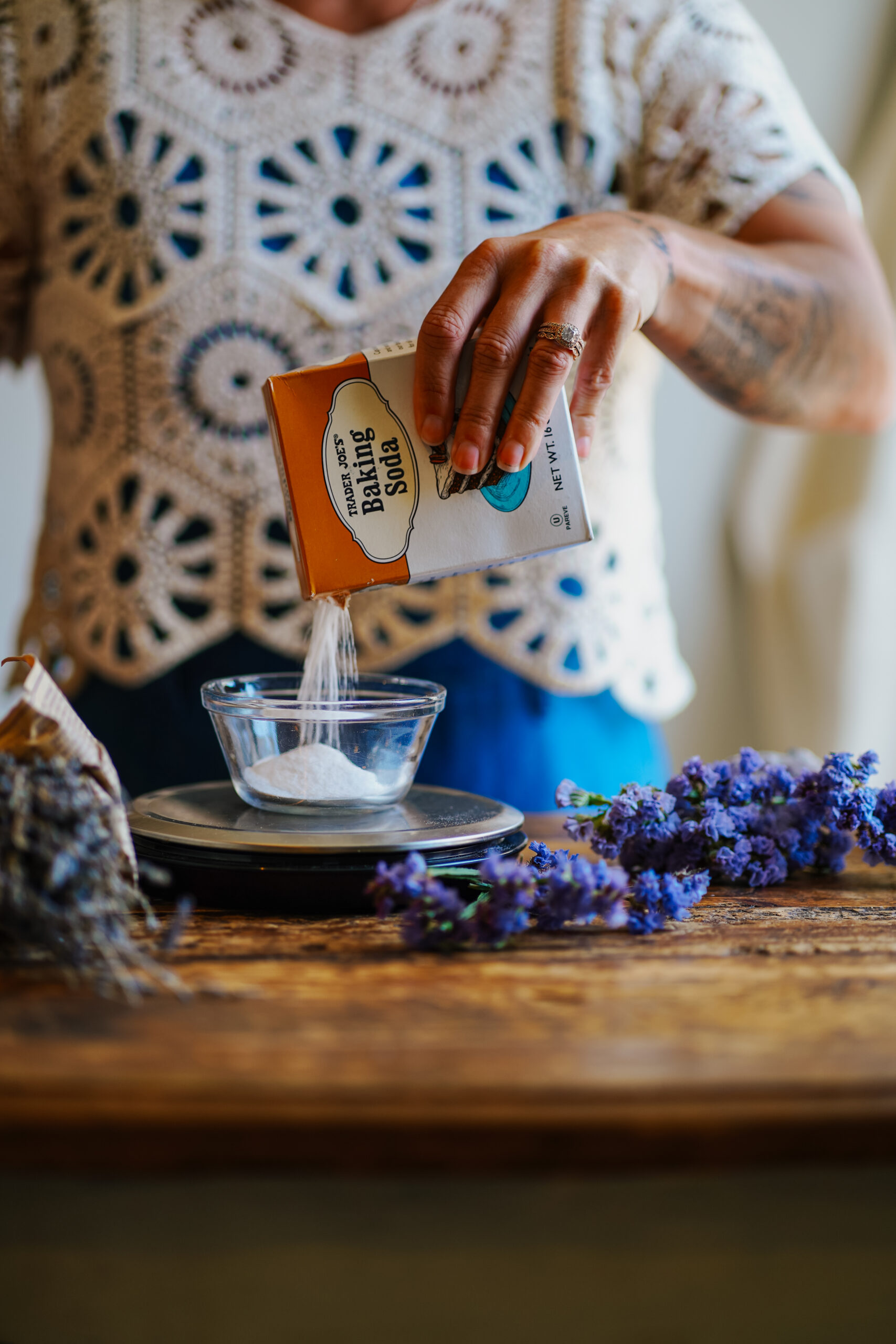 woman pouring baking soda into a glass bowl