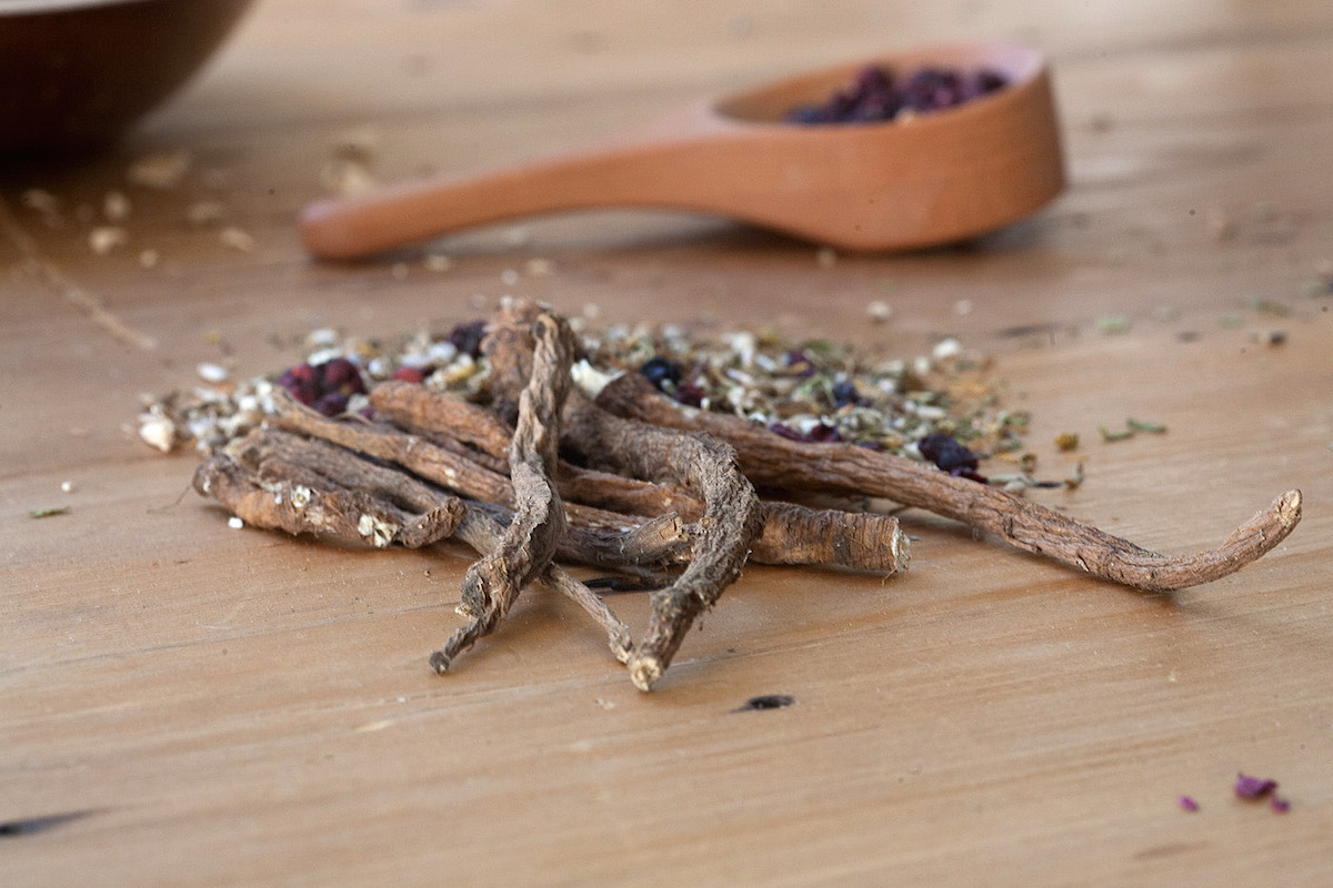 Dried dandelion roots on a wooden surface.