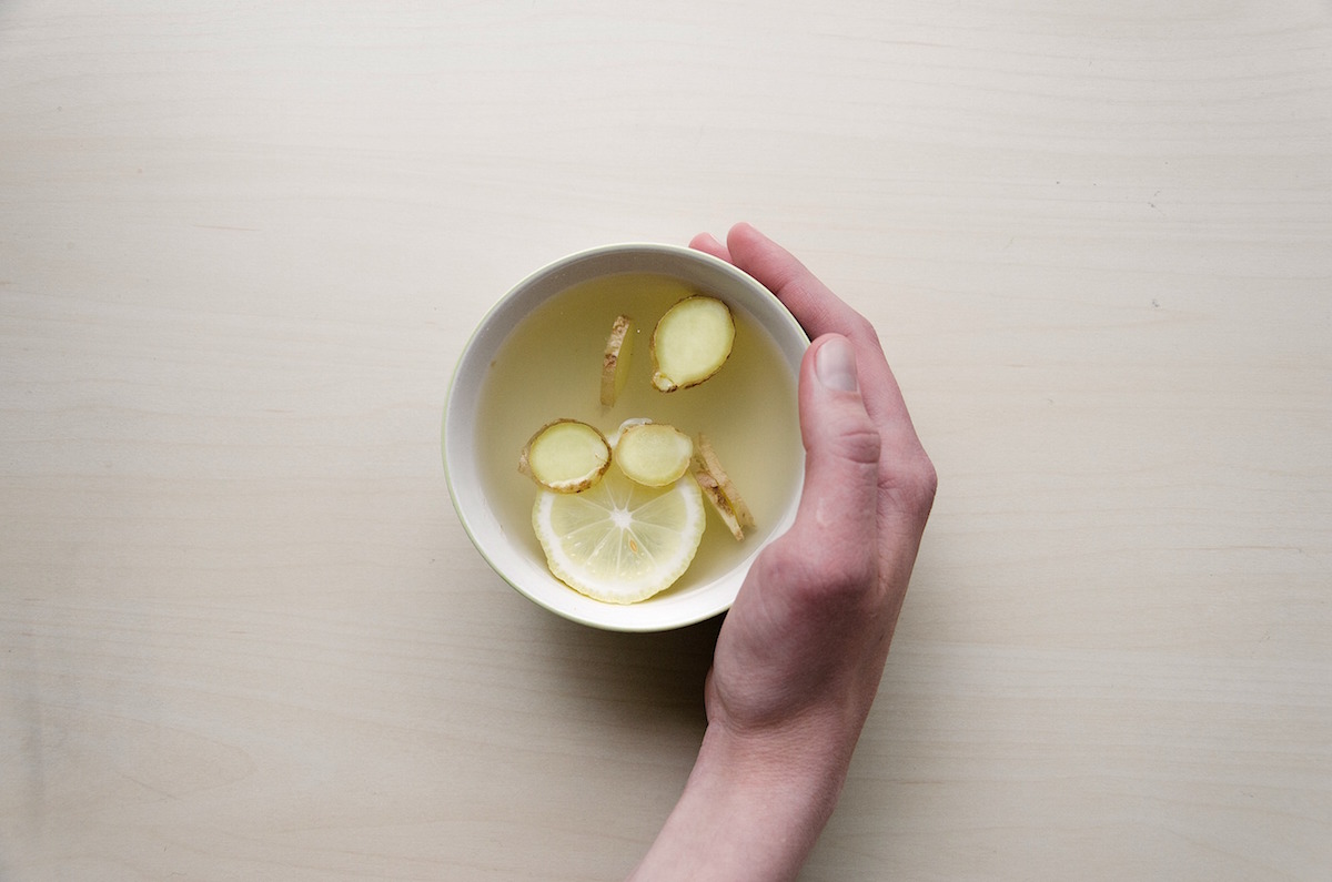 hand holding a mug of lemon and ginger tea