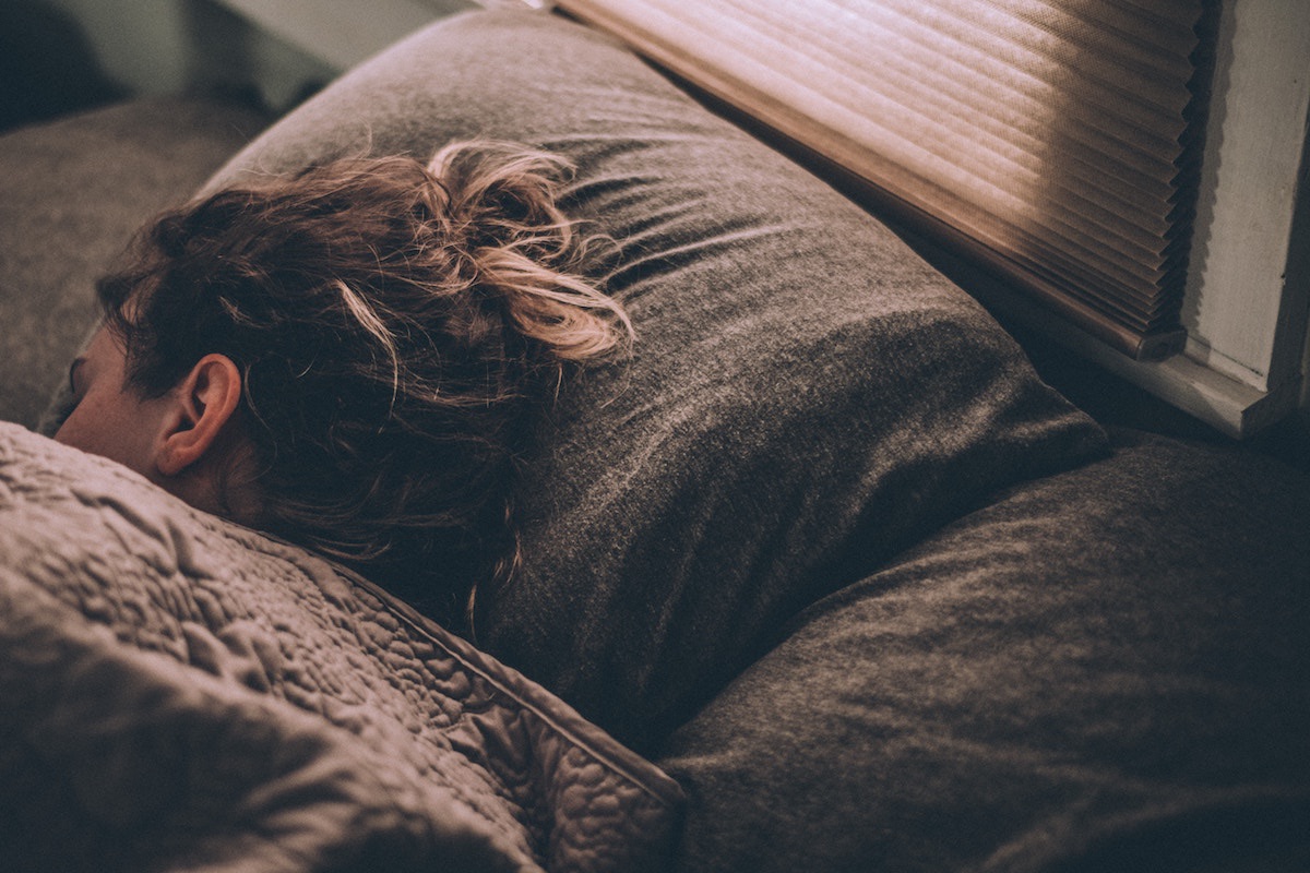 woman sleeping on a pillow under the covers