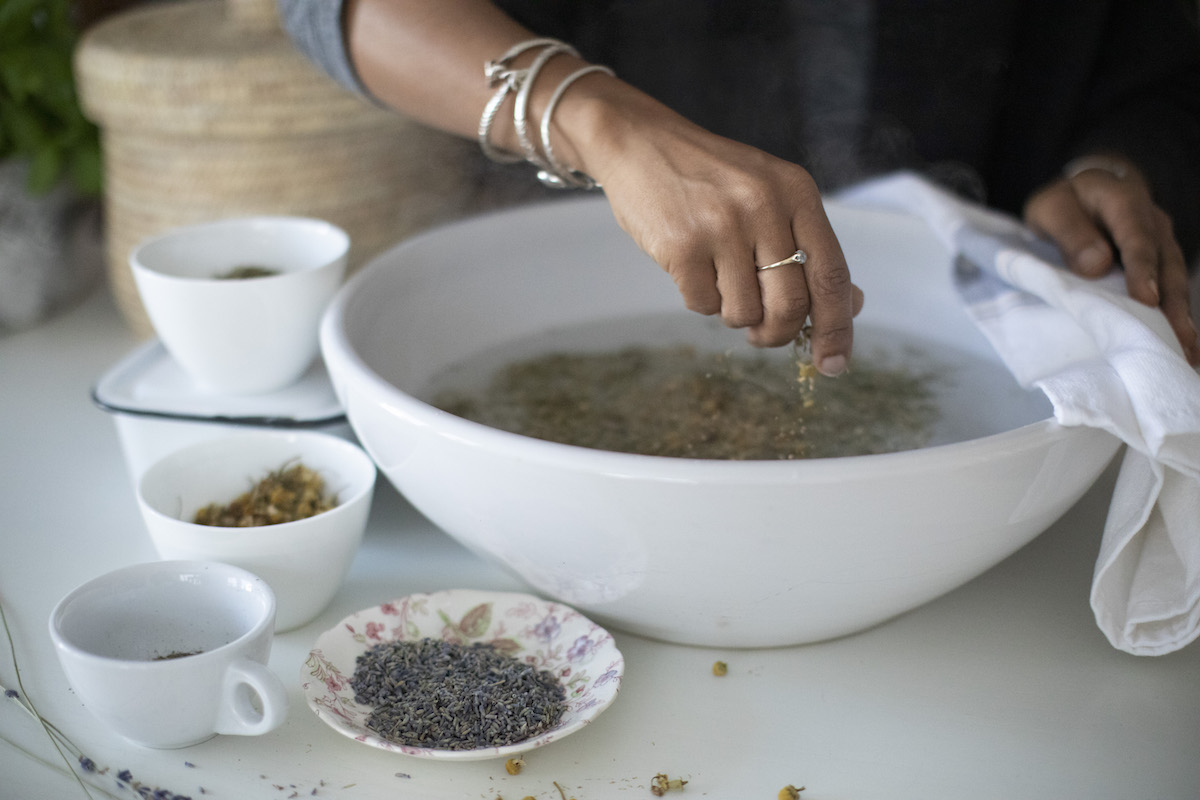 dropping herb into a bowl for steam inhalation