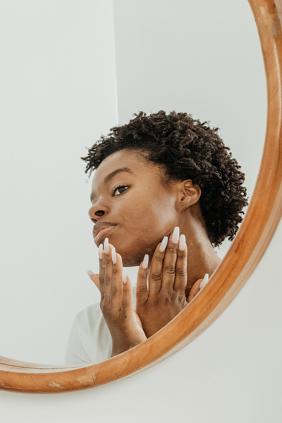 woman looking at her skin in a mirror