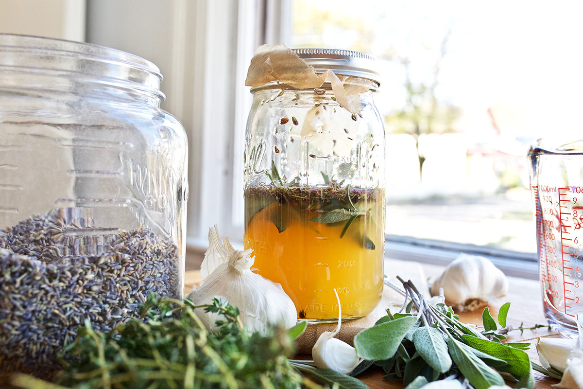 steeping herbs in a jar with a jar of lavender next to it