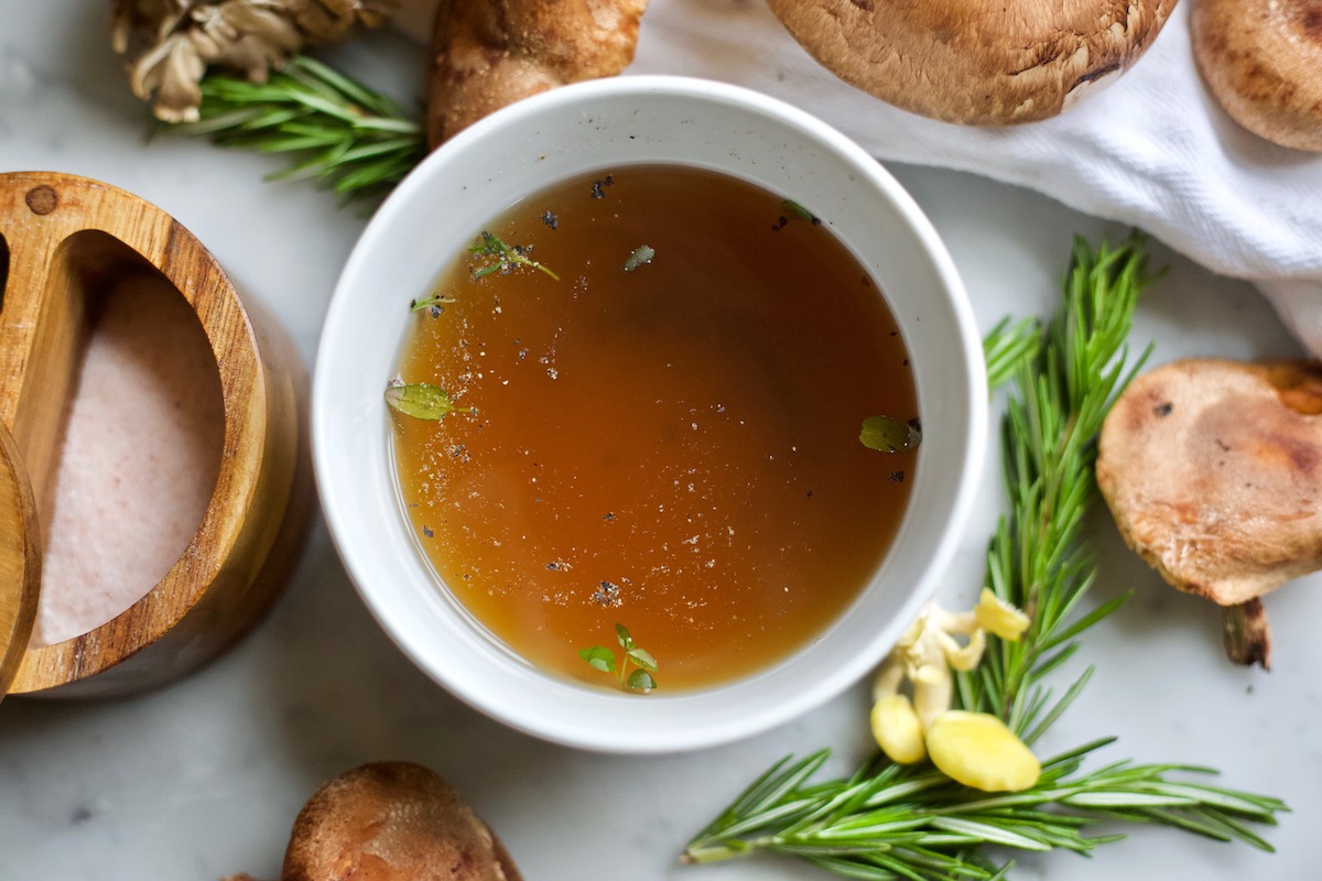 broth in a bowl with herbs and mushrooms 