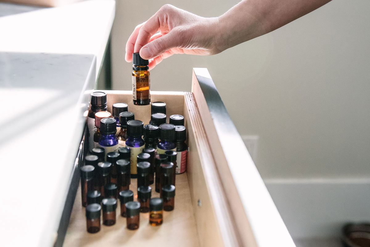 hand removing essential oil from a drawer