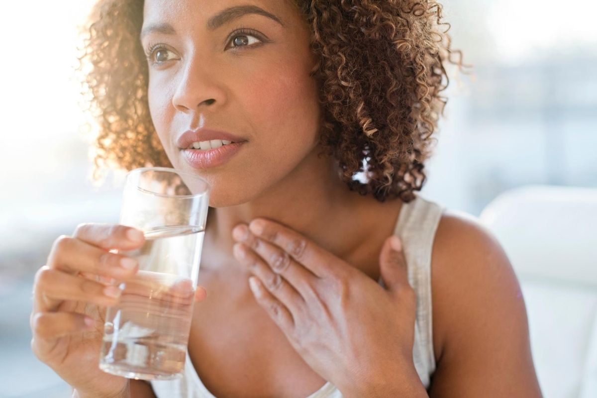 A beautiful black woman drinking a glass of water