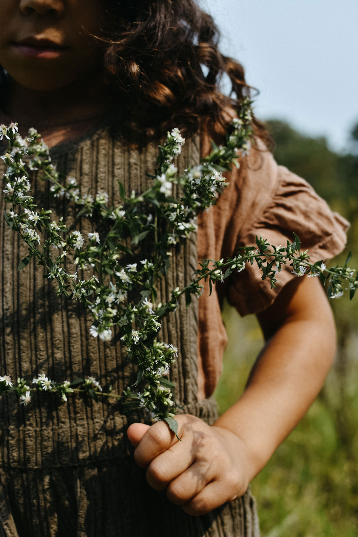 Child holding an herb sprig