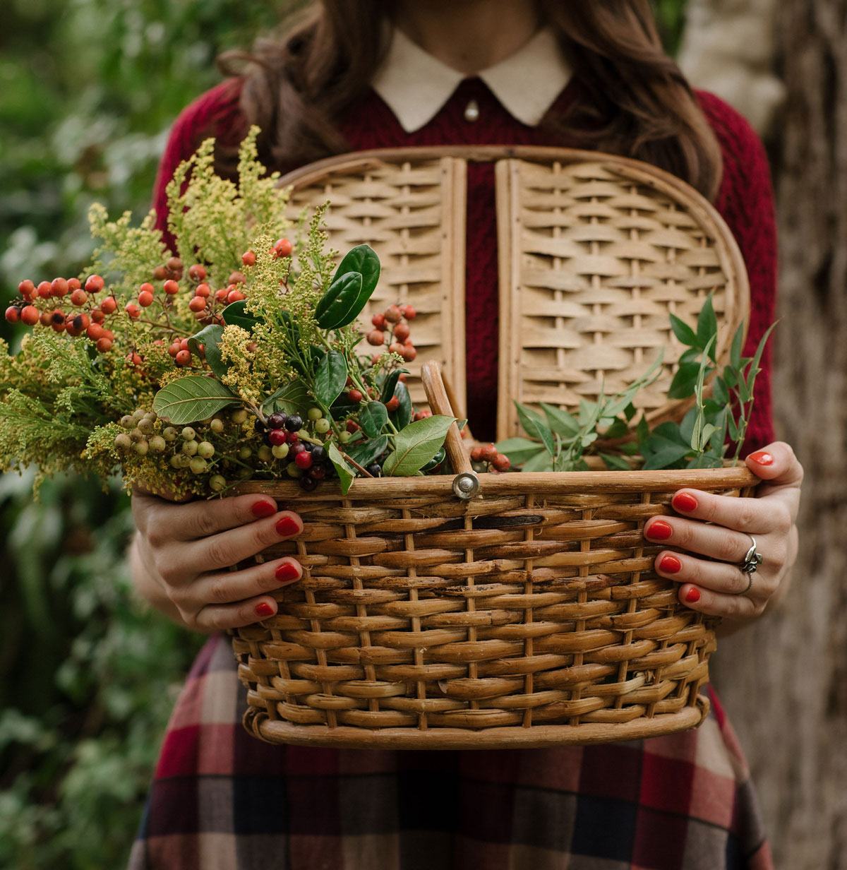 Woman in red sweater holding a foraging basket with goldenrod in it