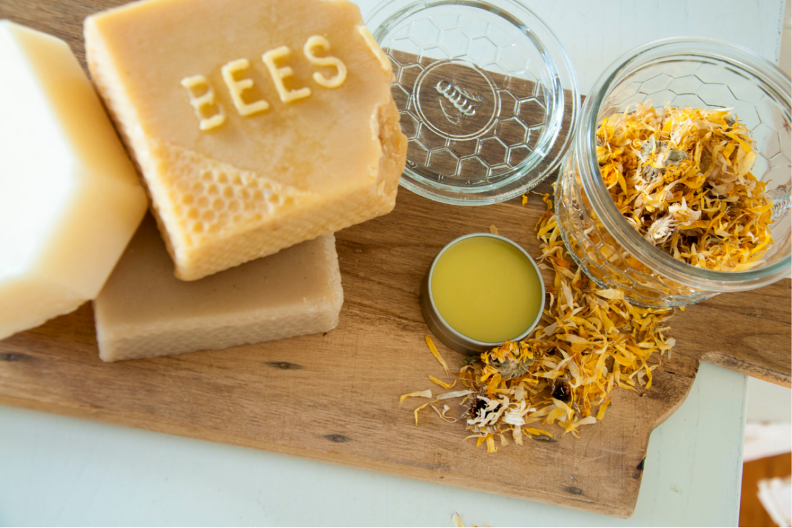 Homemade Nipple Balm with Marshmallow and Calendula | Herbal Academy | bees wax and flowers on table