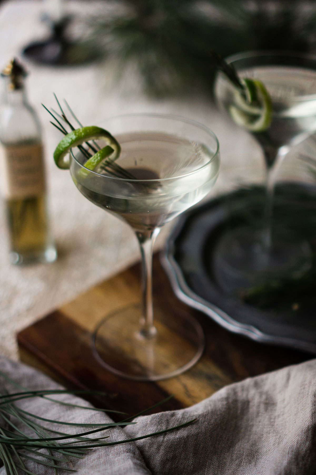 pine needle gimlet on a wooden cutting board