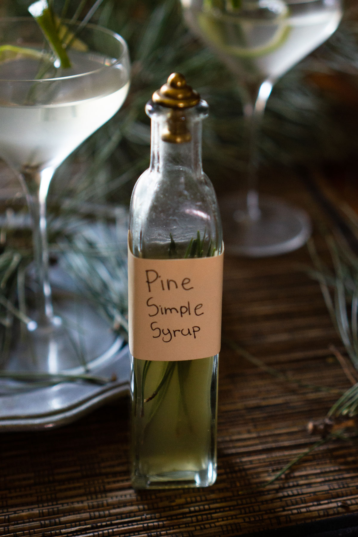 Pine needle simple syrup bottle on a table