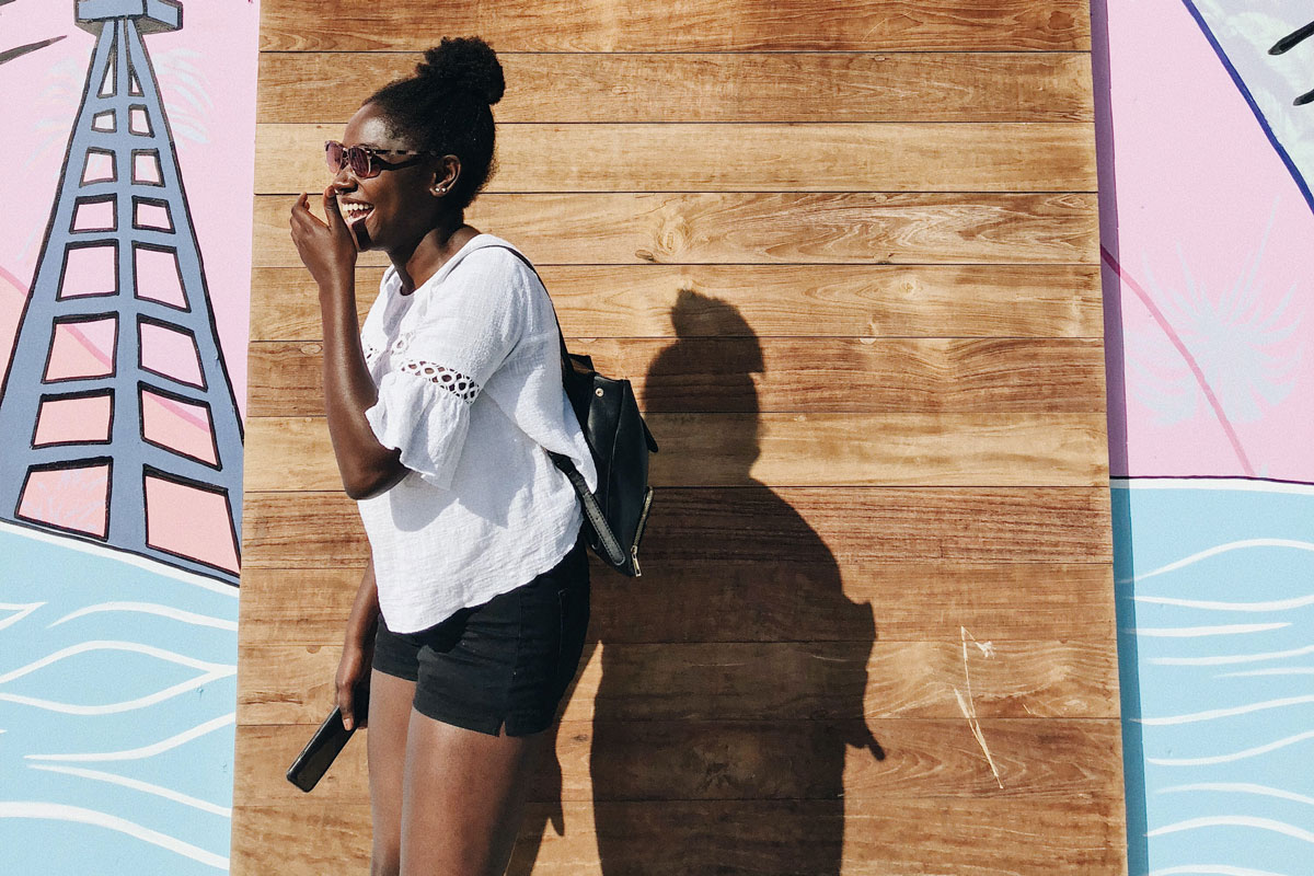 A happy woman standing outdoors in the sunshine