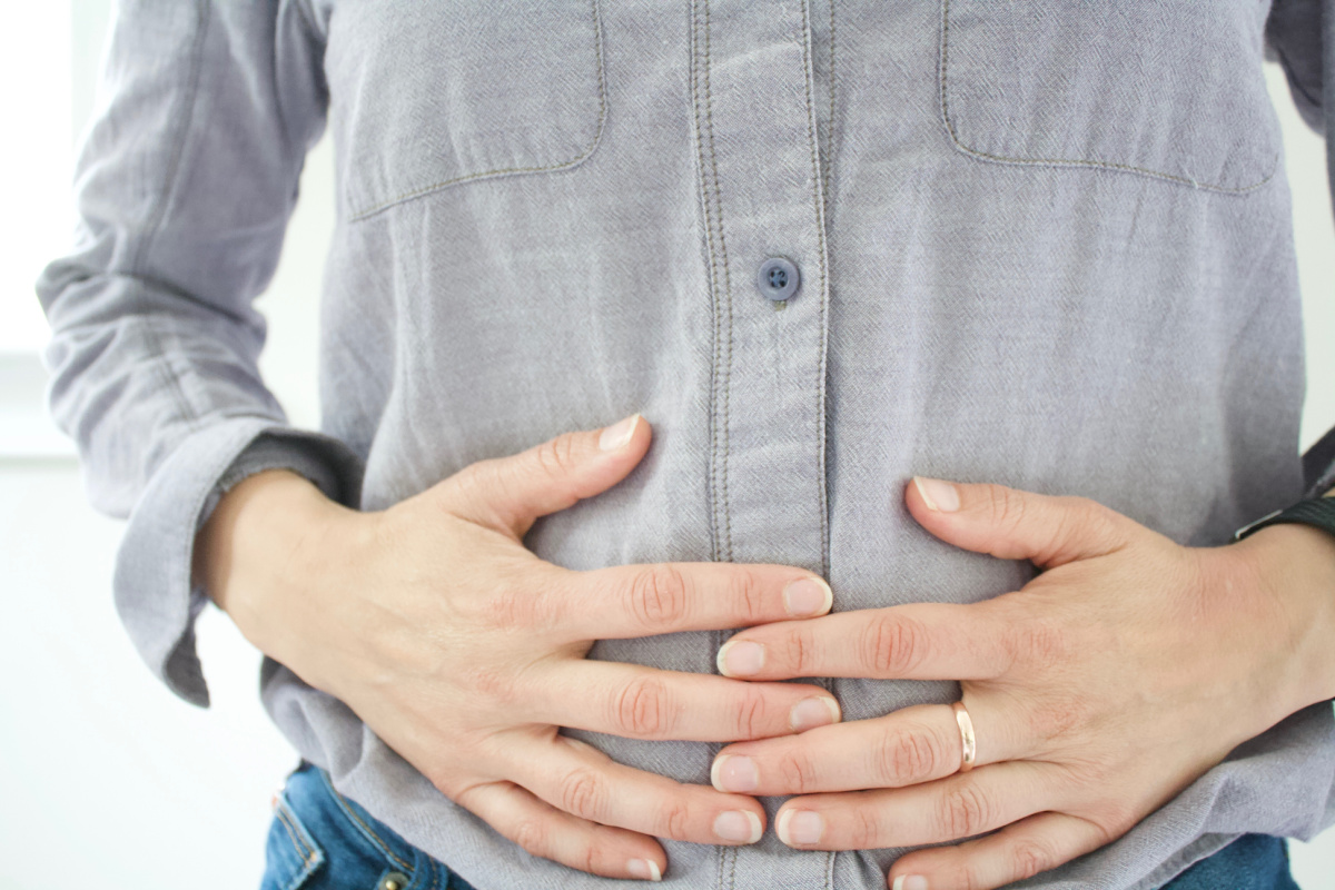 woman holding her stomach as if she has a stomach ache