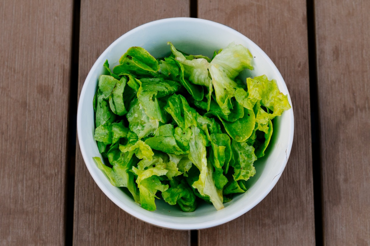 white bowl of salad greens: a good source of iron for nutrient deficiencies