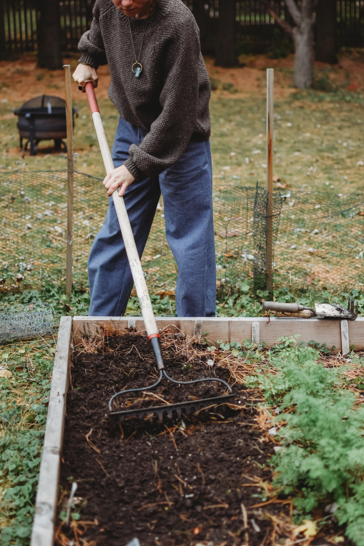 woman digging in the soil with a rake