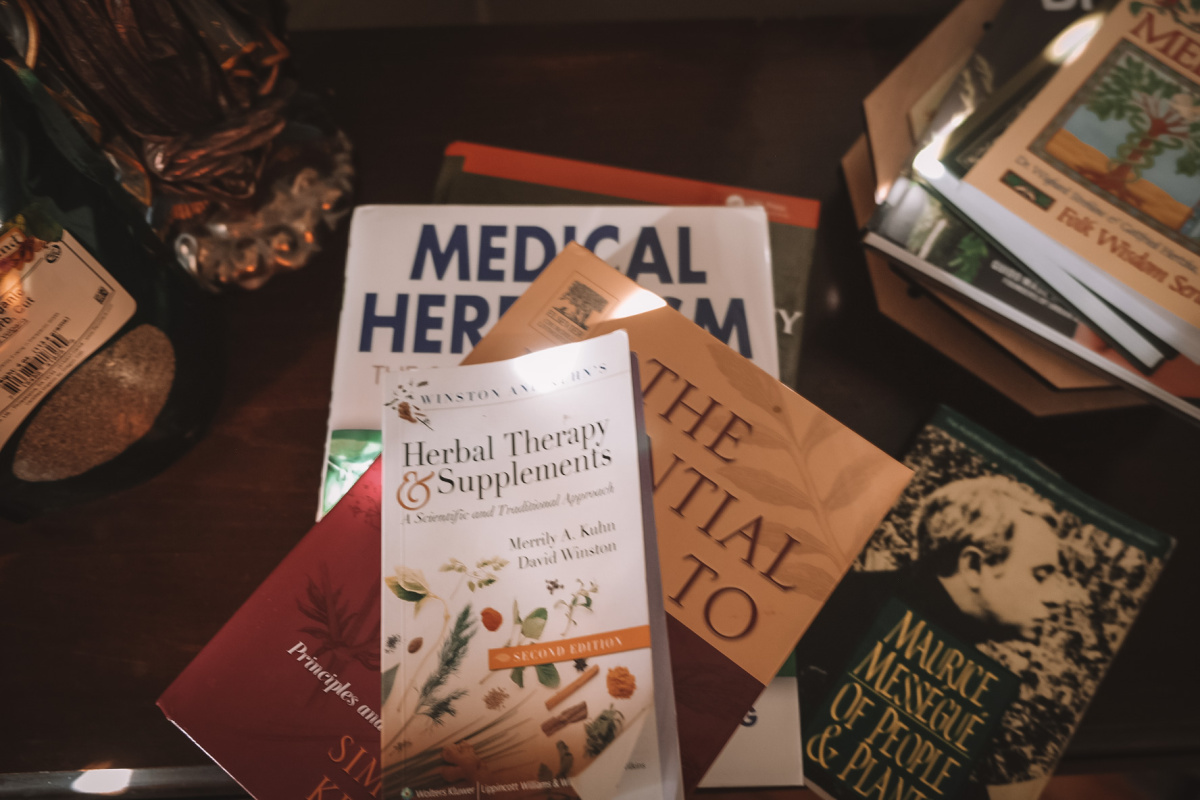 stack of herbal books on a table