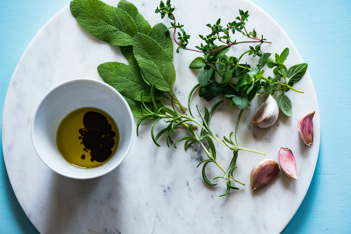 olive oil, herbs, and garlic on a stone platter