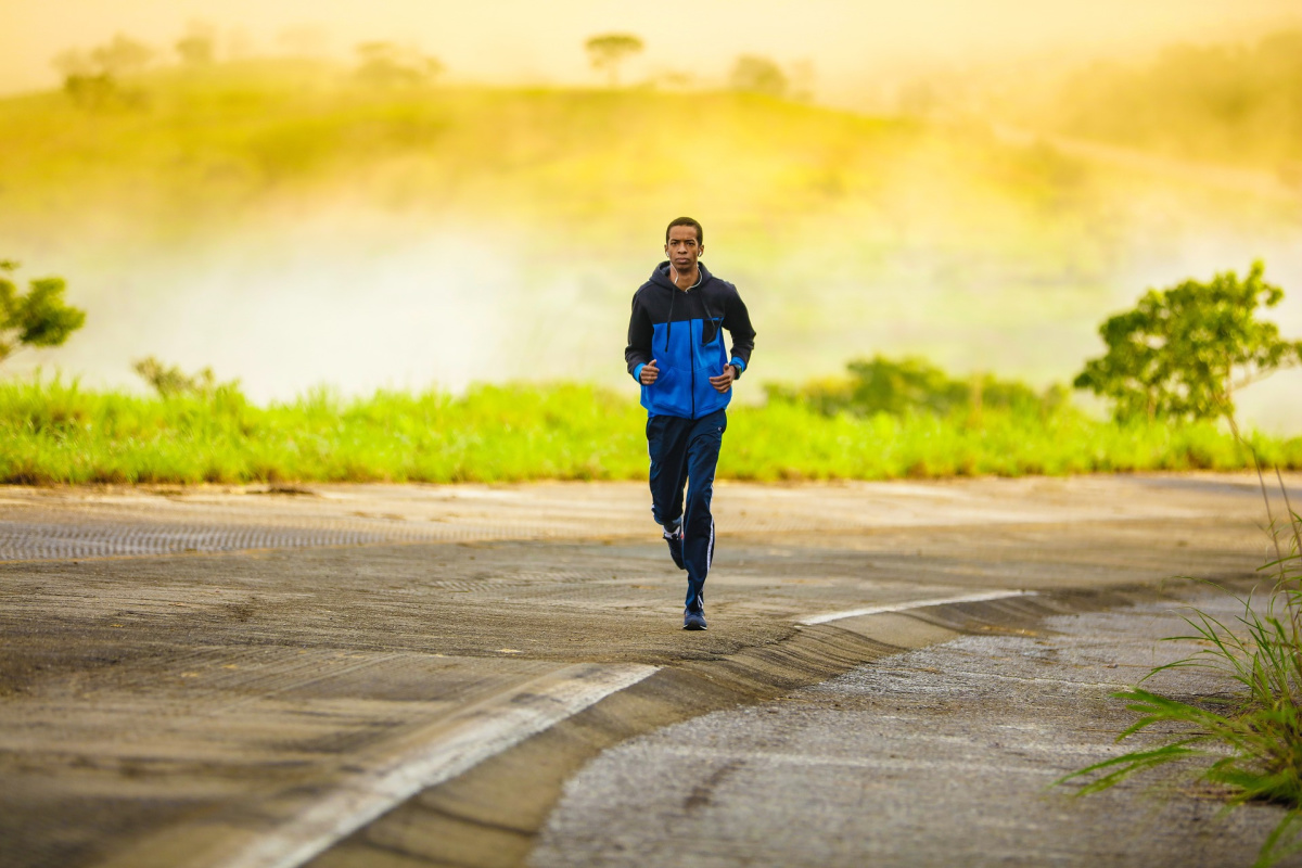 man jogging down a paved road