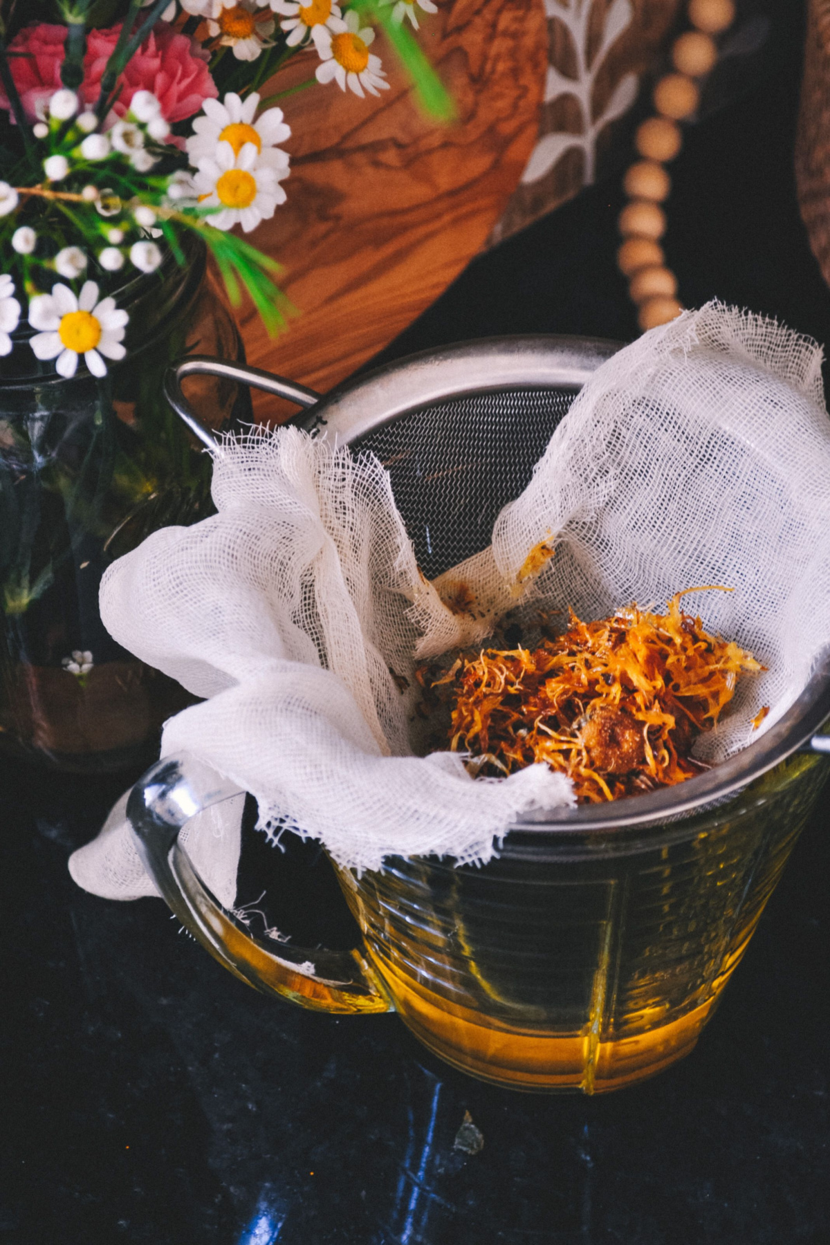 straining herbs through cheesecloth