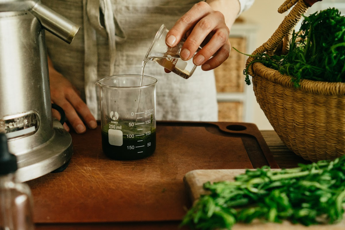 pouring alcohol into plant juice to make a succus