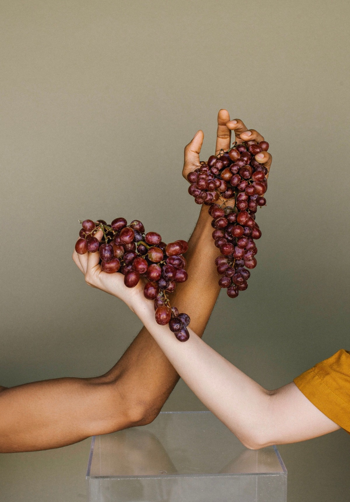 two hands holding grapes