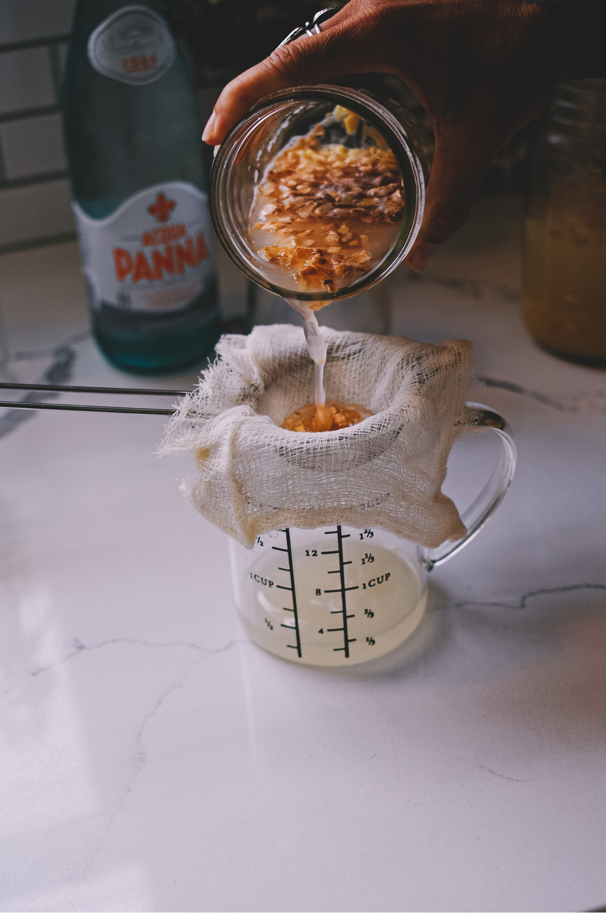 pouring ginger bug into a measuring cup