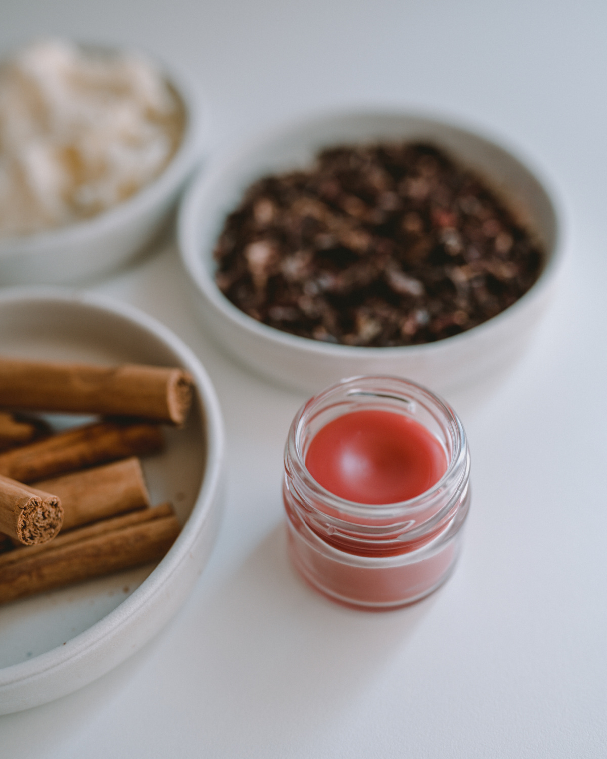 lip balm on a table with ingredients in the background