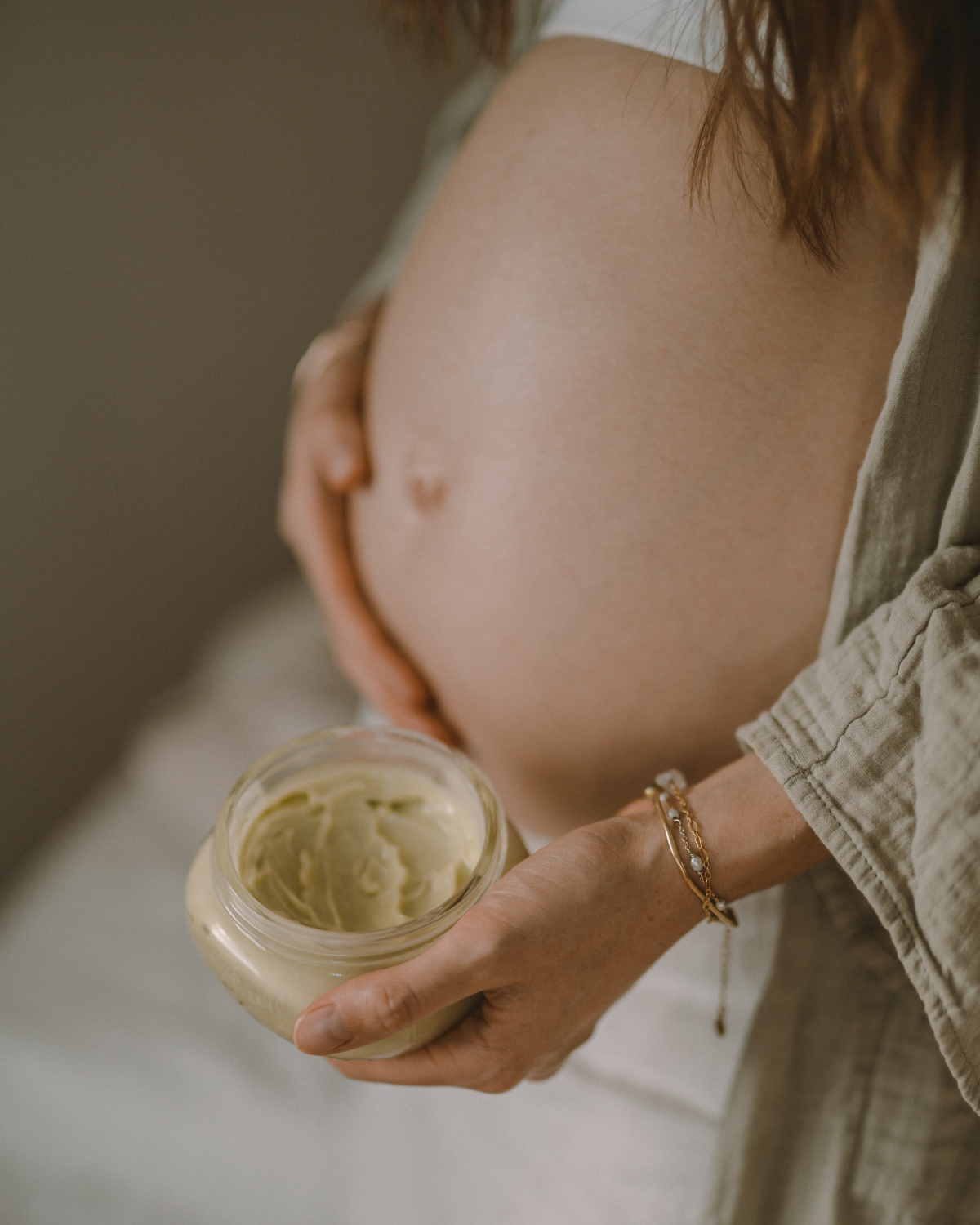 woman applying pregnancy belly cream to her belly to prevent stretch marks