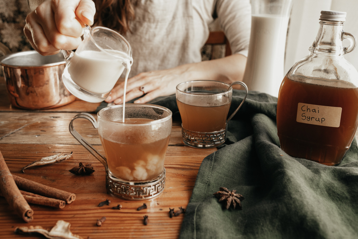 pouring milk into glass to make chai tea