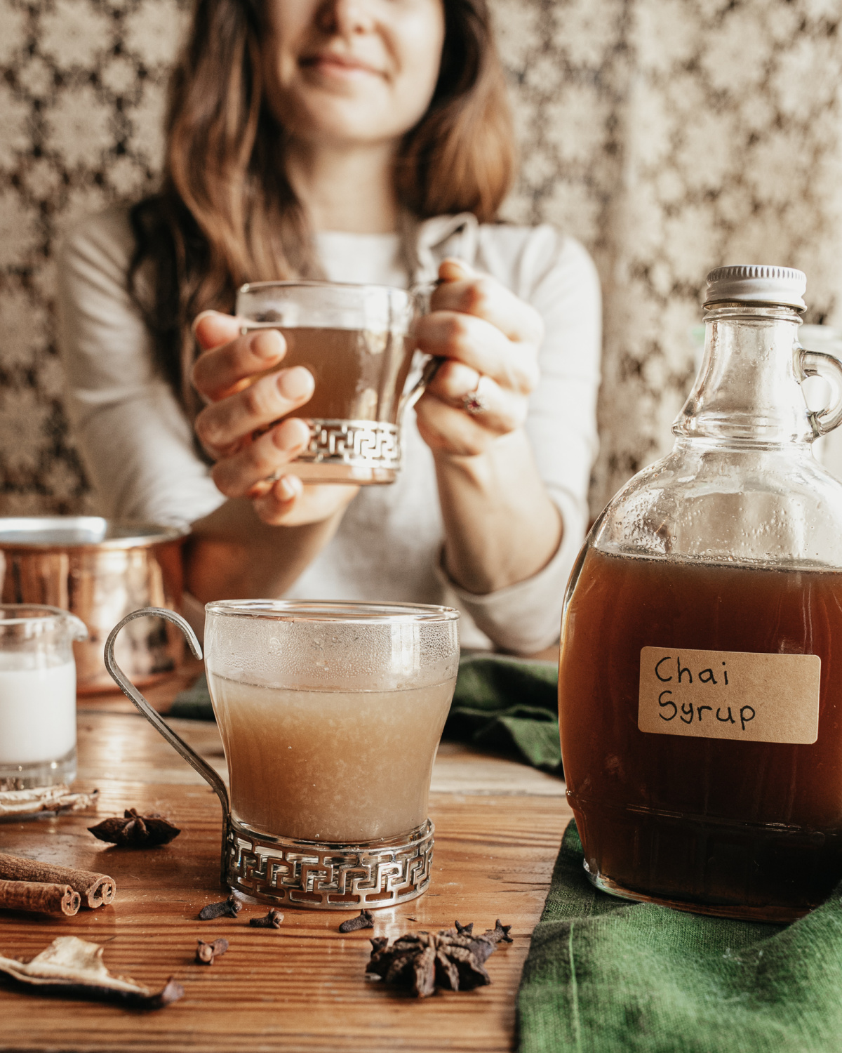 woman holding a glass of chai syrup