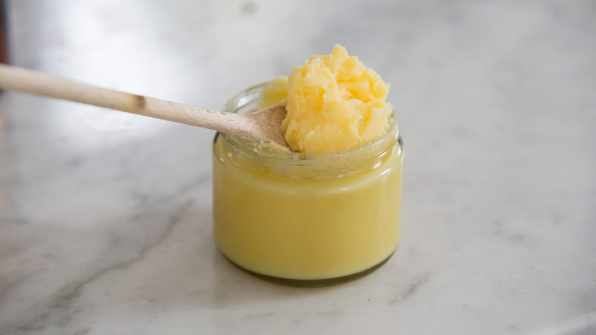 ghee in a jar with a wooden spoon