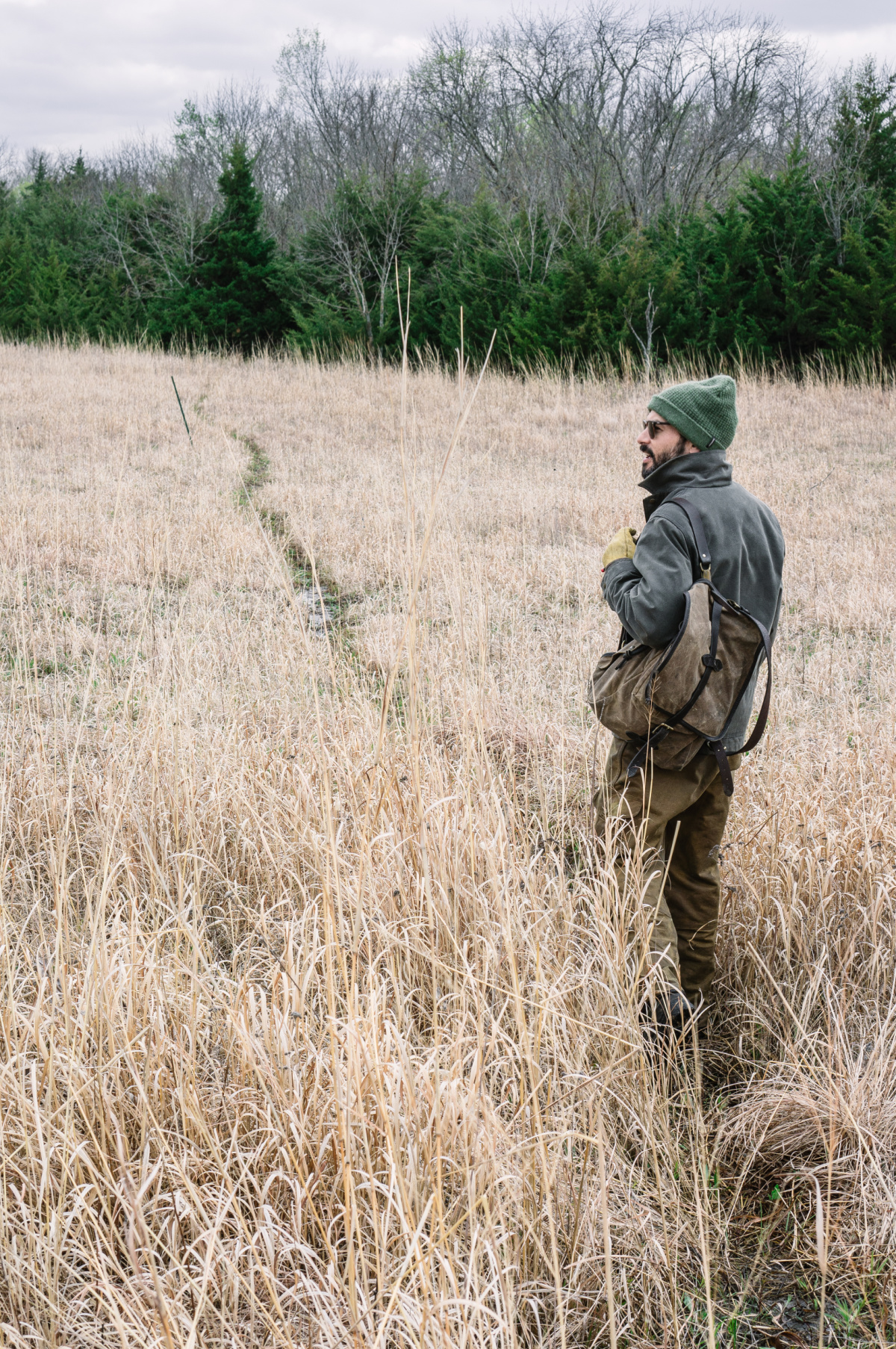 man hiking through a field