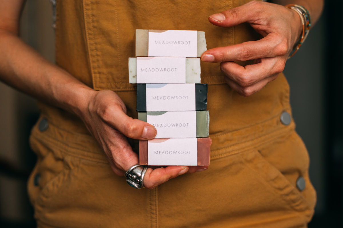 man holding a stack of handmade soap