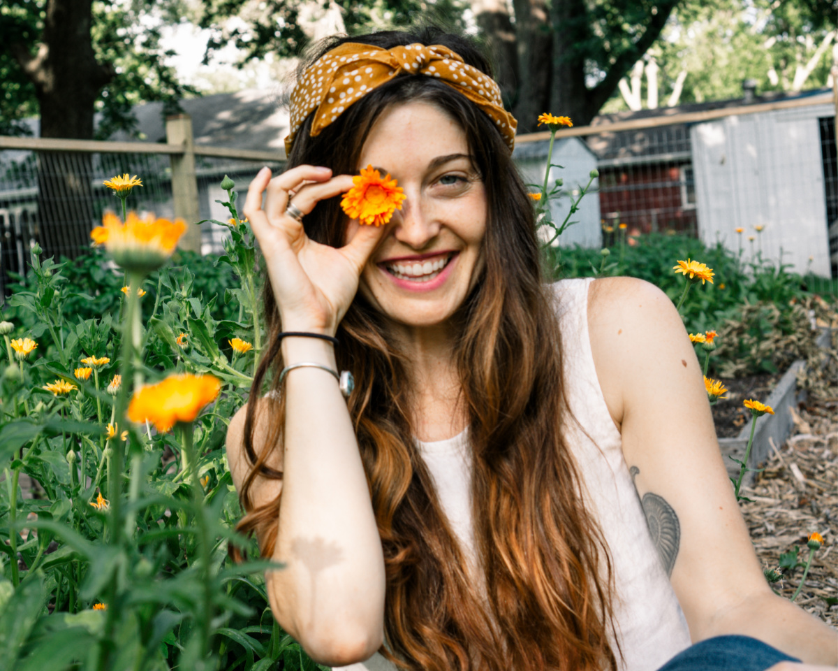 herbalist holding a calendula flower to her eye