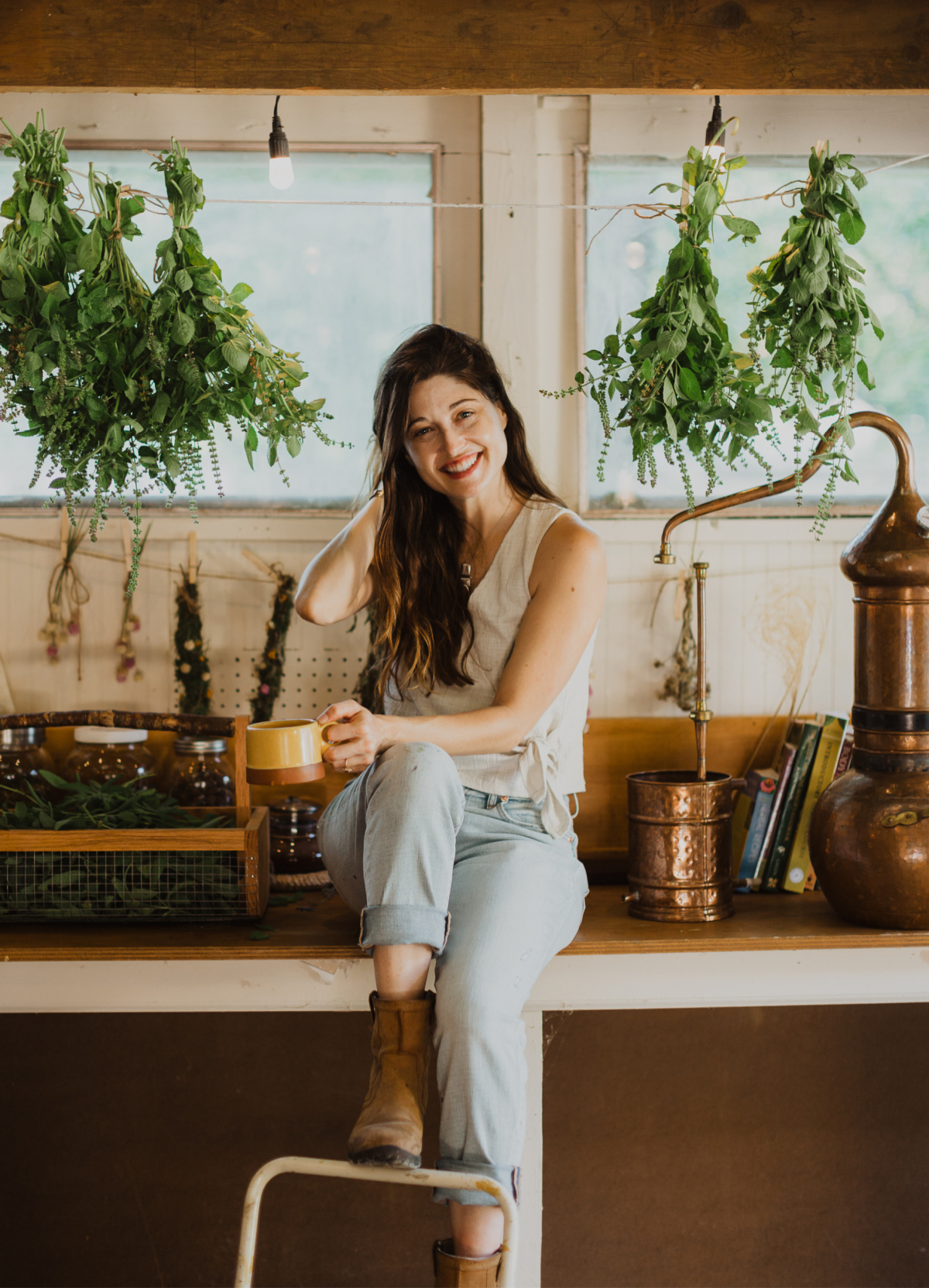 Hannah Larsora sitting on a table holding cup of tea