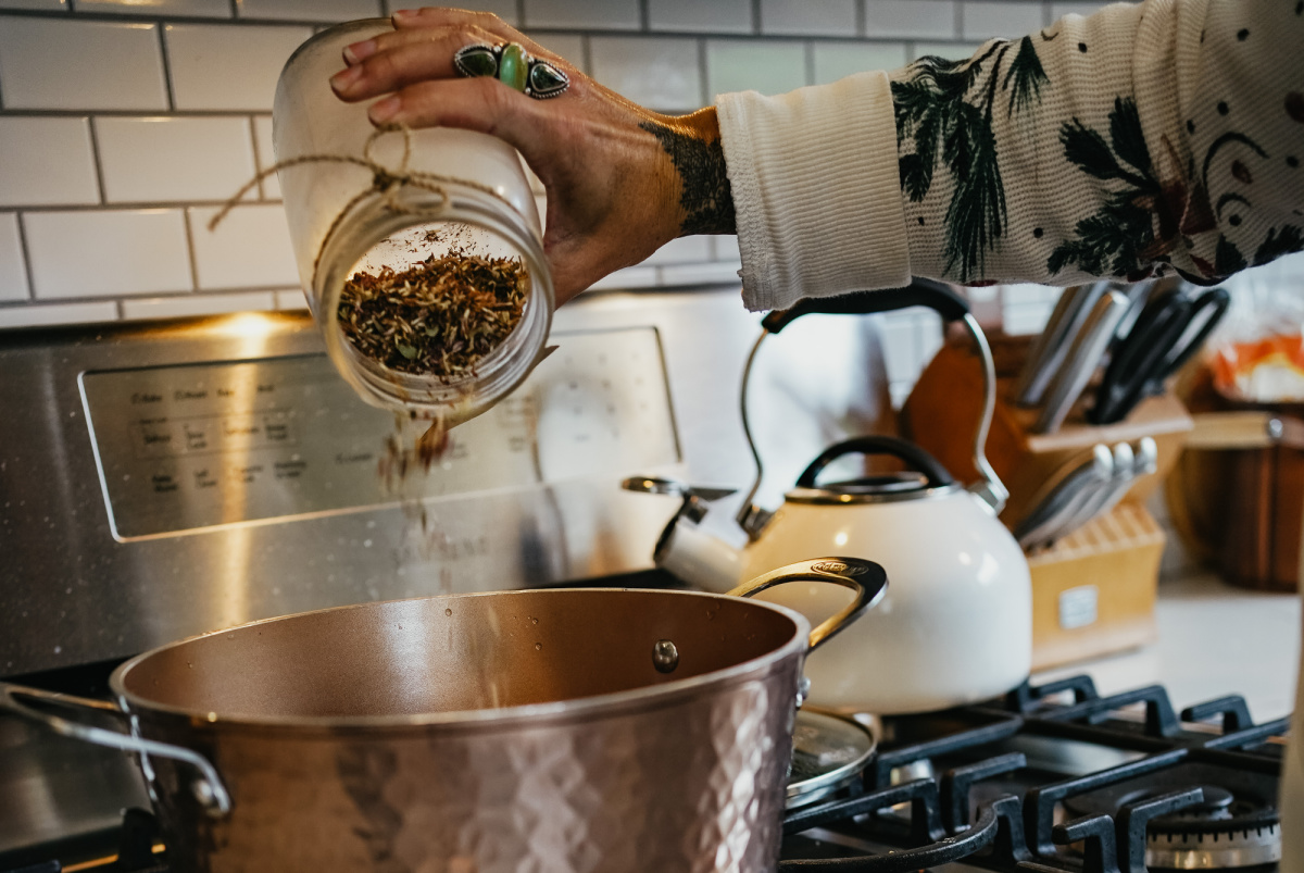 pouring herbs into a pan of water