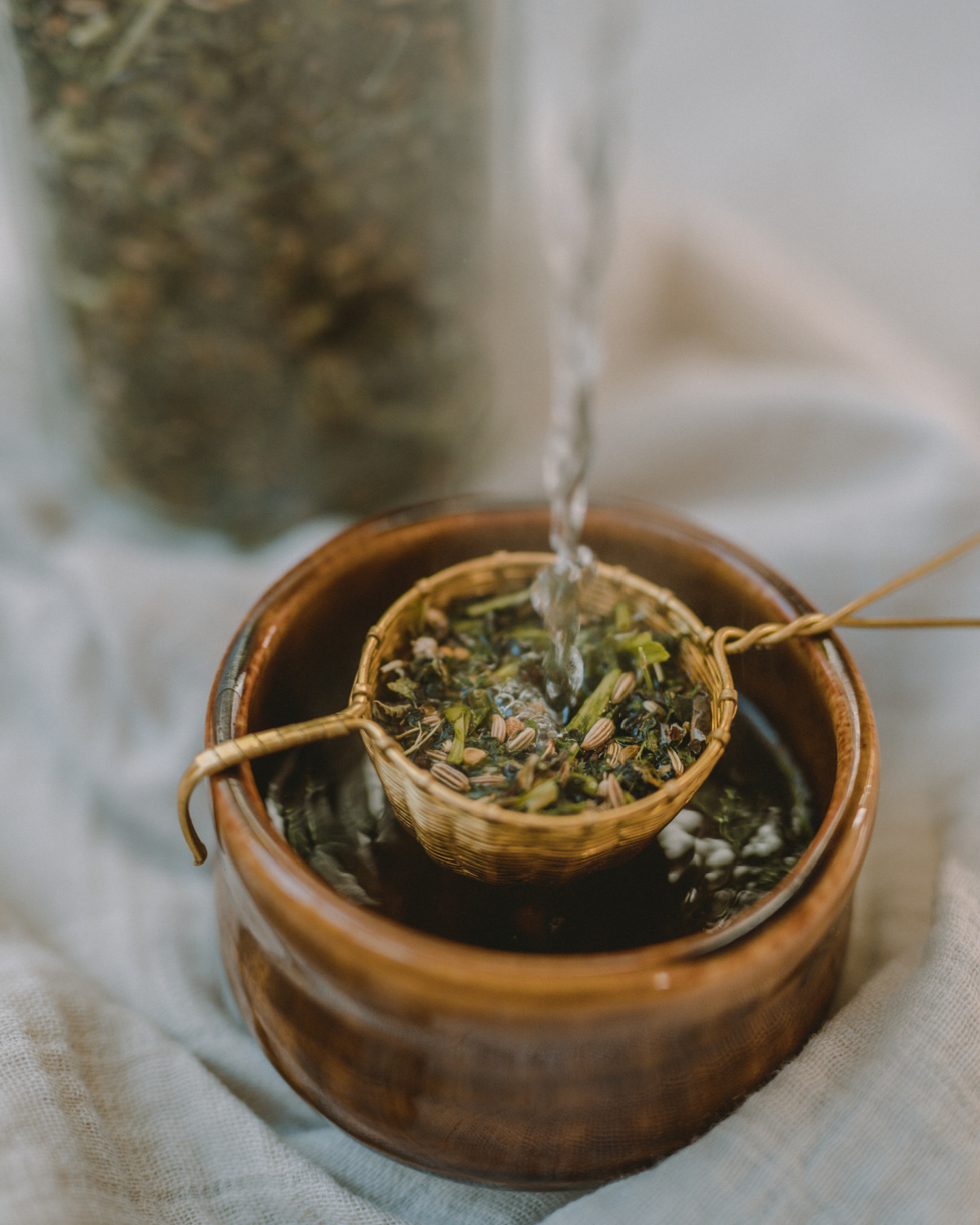 pouring water through healthy nursing tea herbs