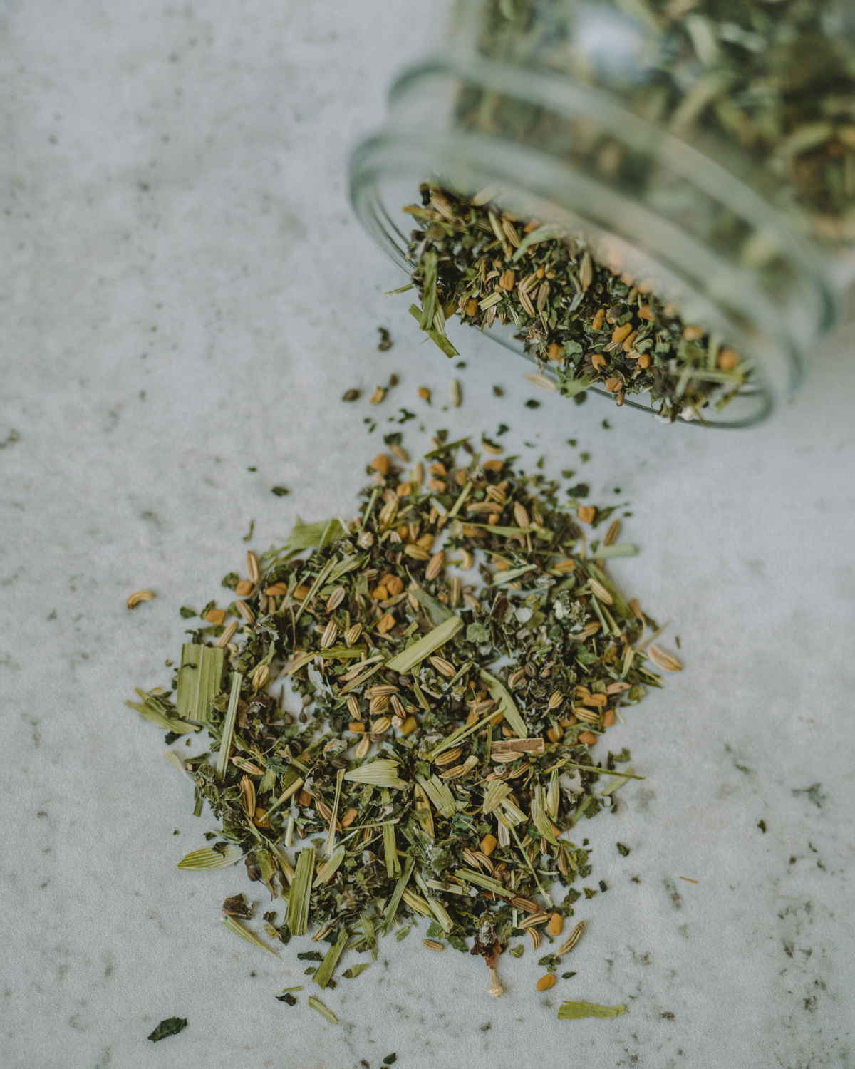 herbs spilling out of jar onto a table