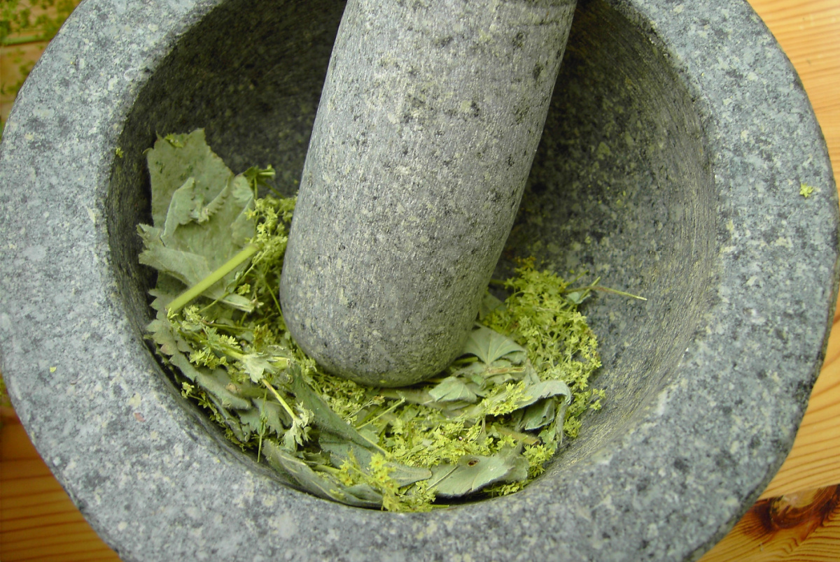 crushing herbs with a mortar and pestle