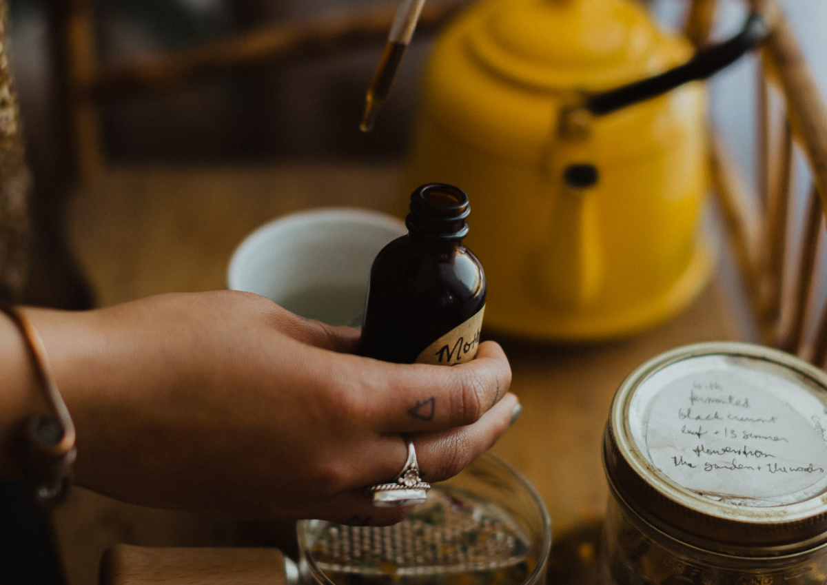 placing herbal tincture into a glass of water