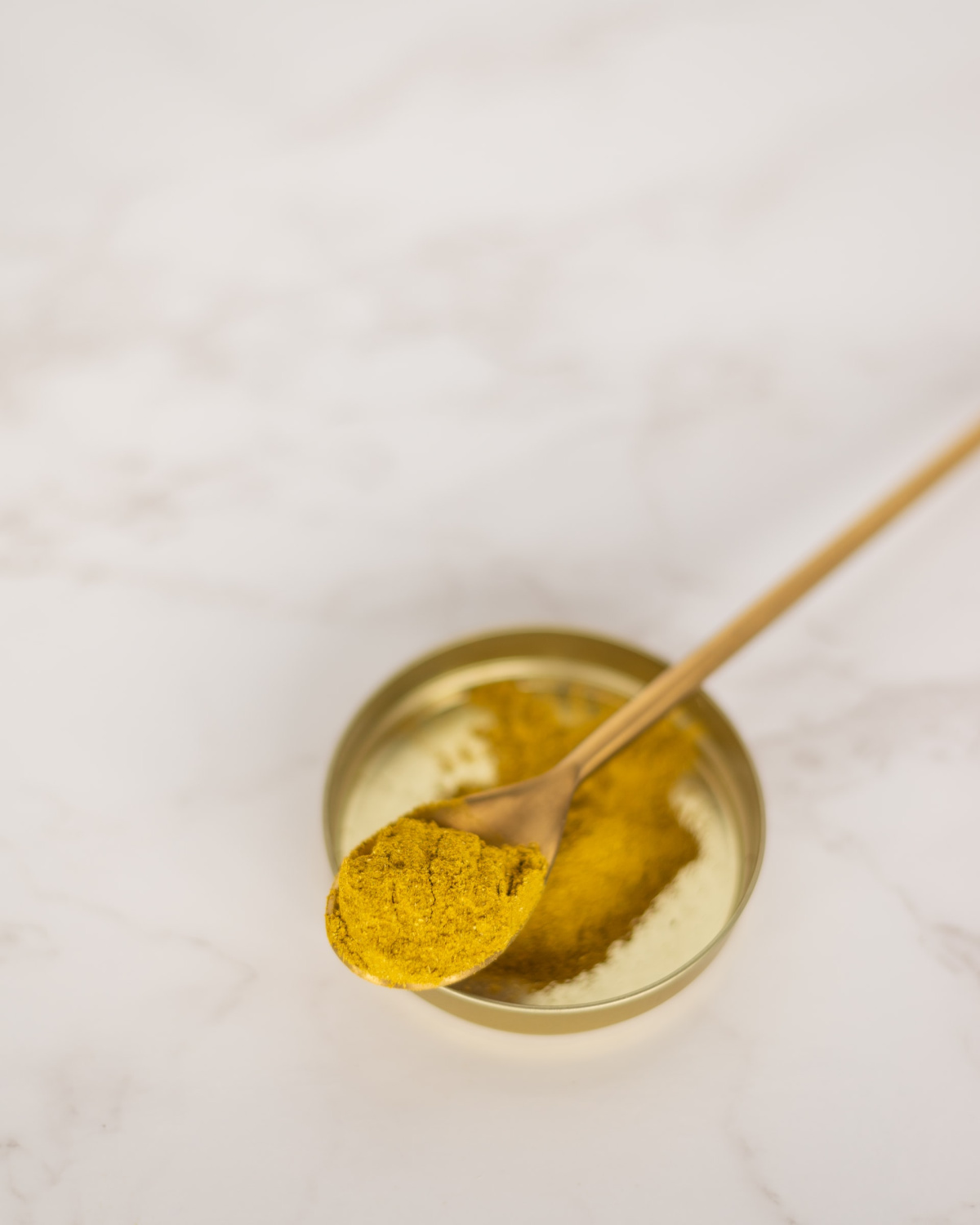 powdered turmeric on a spoon for DIY skin care