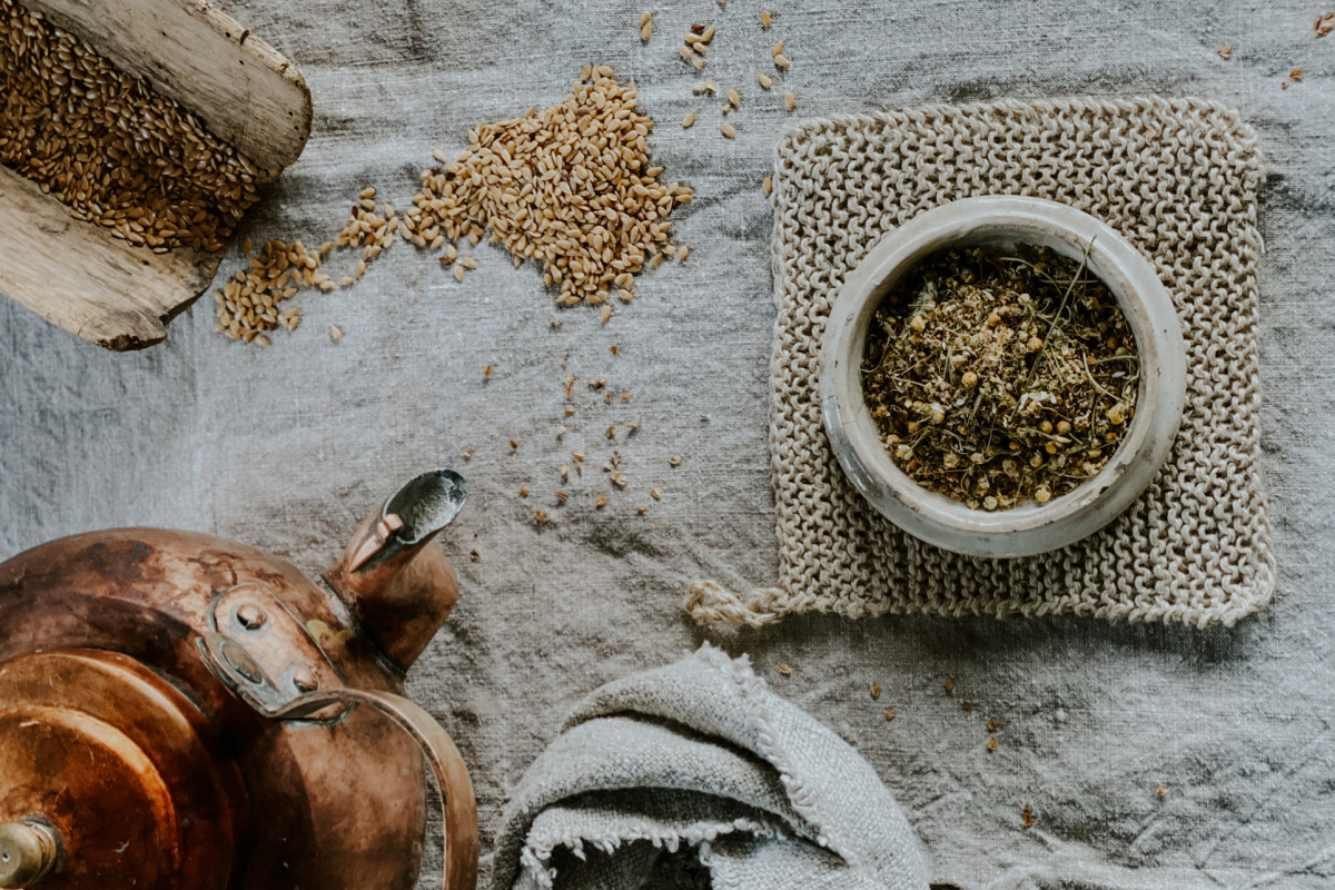 dried herbs and tea pot on tablecloth