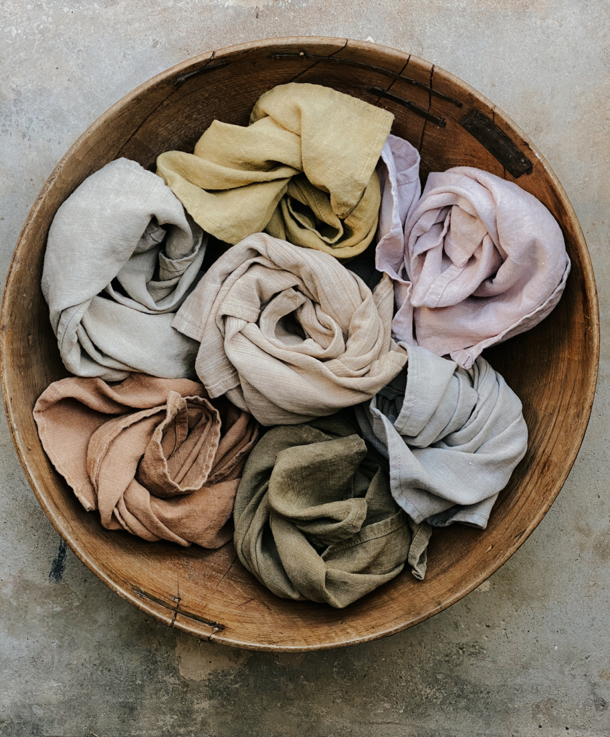 wooden bowl filled with herbal dyed cloths