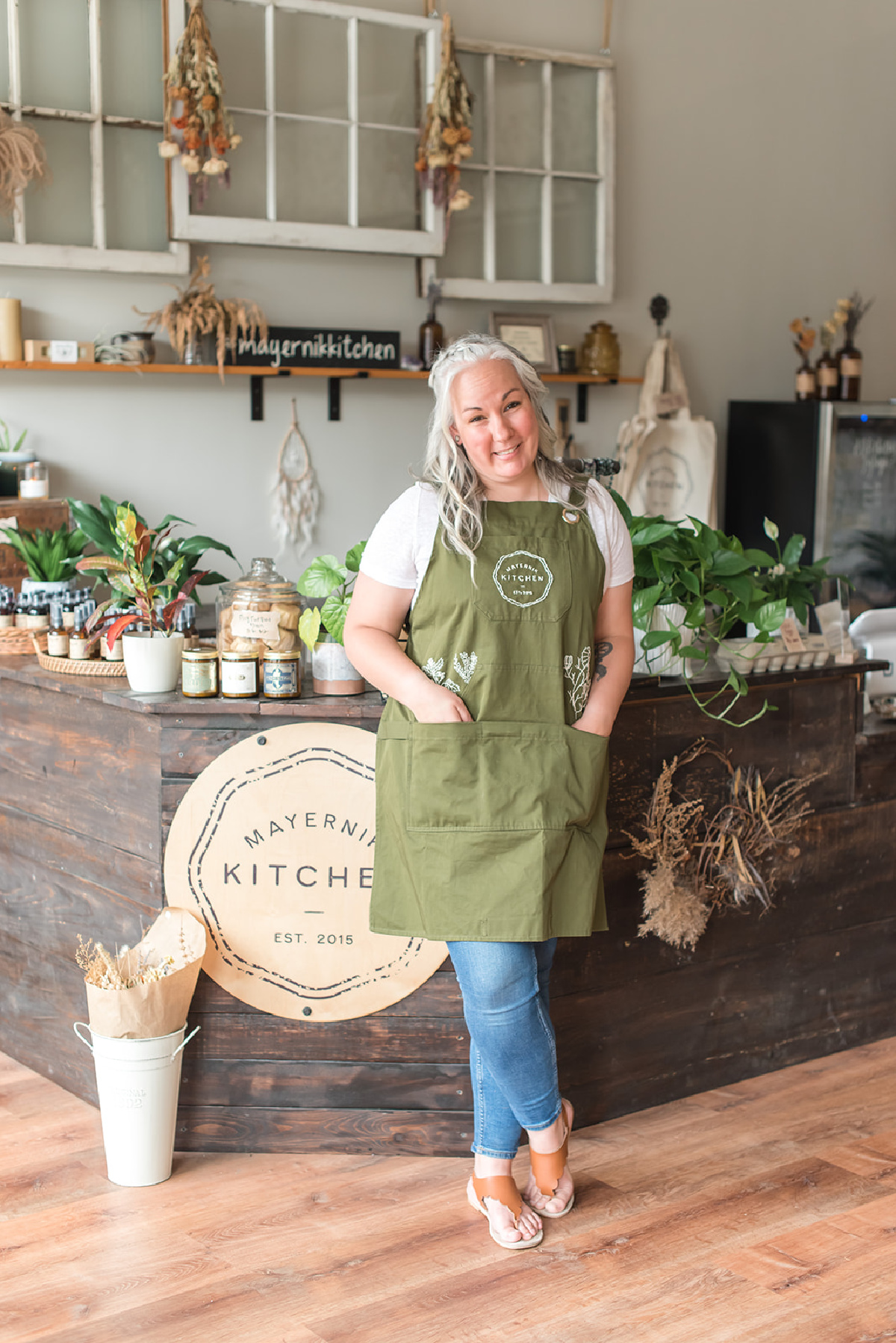 herbalist standing in front of counter full of herbs