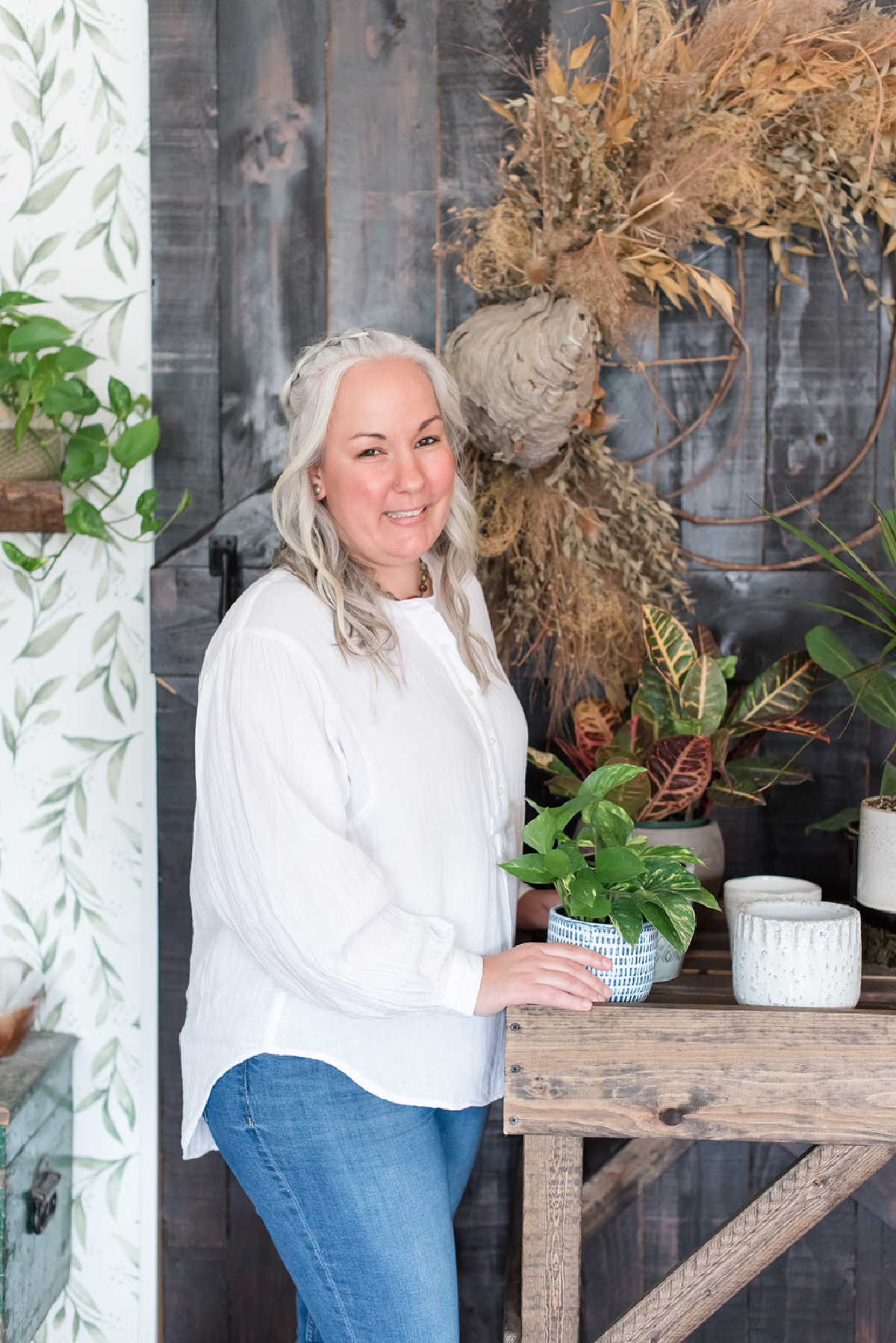 herbalist standing next to table of plants