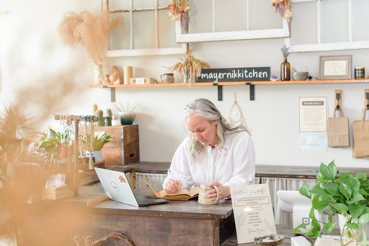 woman sitting at desk with laptop and notebook