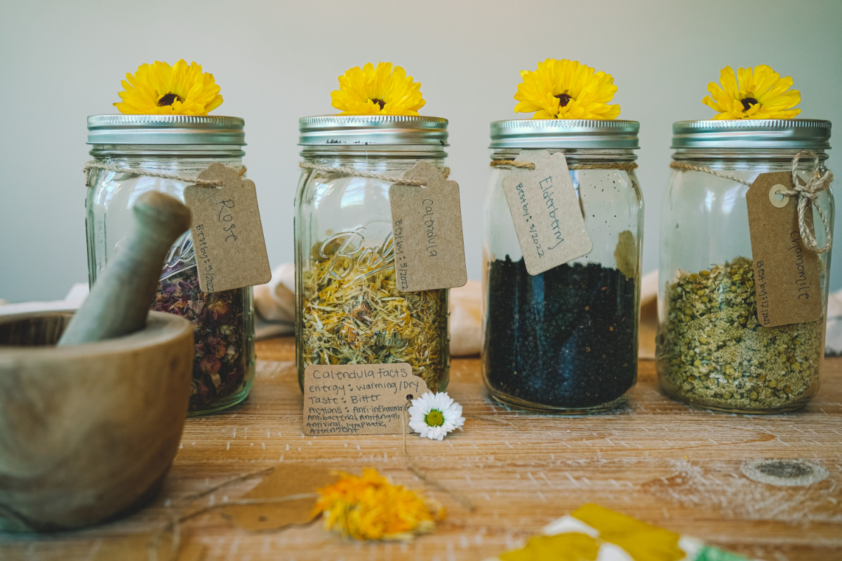 jars of dried herbs with herbal tags