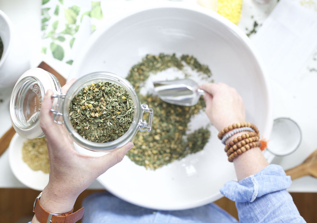 scooping tea blend into glass container