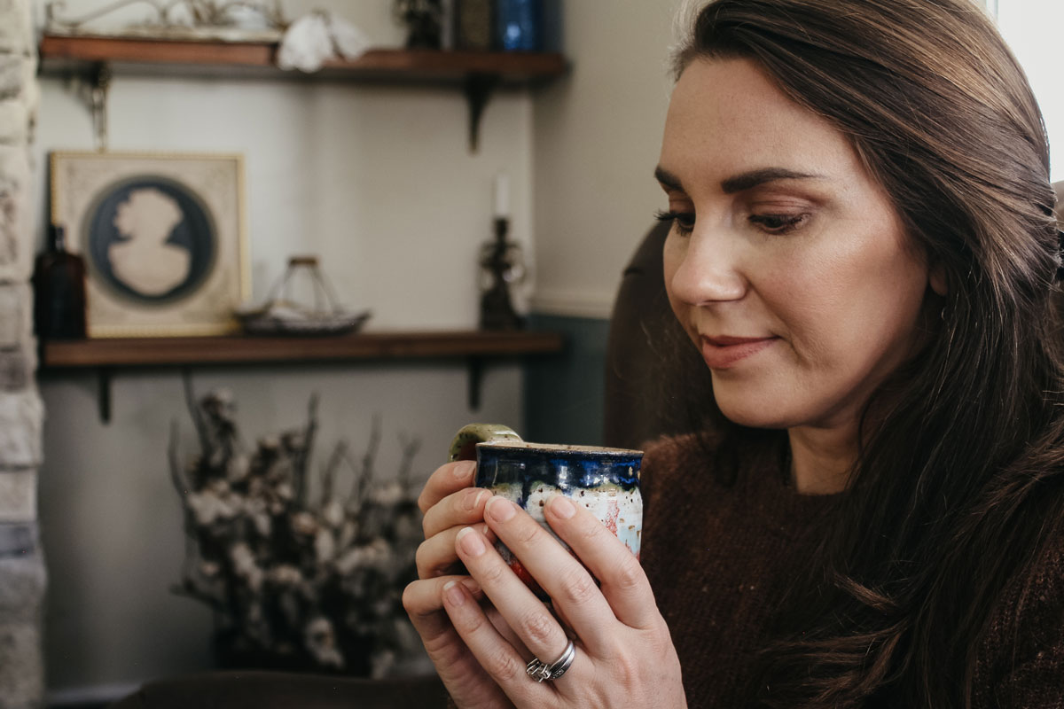 woman looking down at a mug of herbal tea